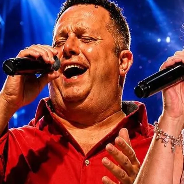 Salvo Vultaggio canta al microfono con la camicia rossa di scena